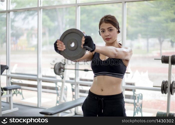beautiful muscular fit woman exercising building muscles and fitness woman doing exercises in the gym. Fitness - concept of healthy lifestyle,soft focus