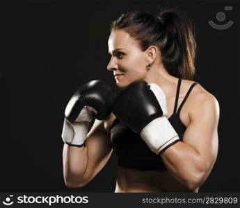 Beautiful muscular fitness woman wearing boxing gloves.