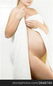 Beautiful naked pregnant woman covering in white bath towel
