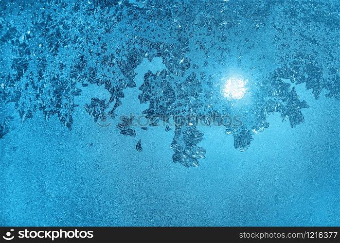 Beautiful natural ice pattern and sunlight on morning winter glass