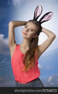 Beautiful, natural, lovely, blonde girl with rabbit, fluffy ears. She wears red top and jeans. She has got nice yellow and brown make up.