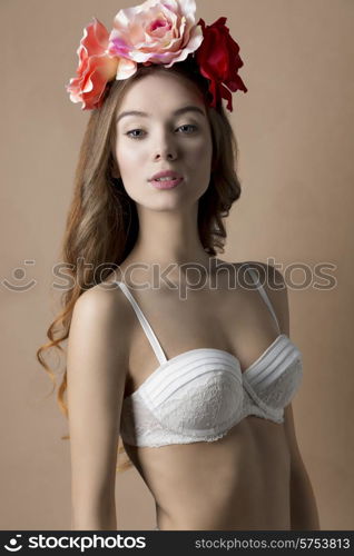 Beautiful, natural, retro, spring woman in white bra and flowers on the head, with long curly hair.