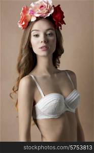 Beautiful, natural, retro, spring woman in white bra and flowers on the head, with long curly hair.
