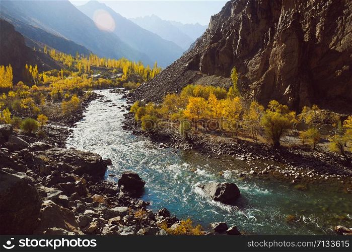 Beautiful nature landscape view of winding river flowing along valley in Hindu Kush mountain range. Autumn season in Gupis Ghizer, Gilgit Baltistan, Pakistan.