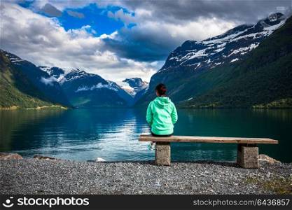 Beautiful Nature Norway natural landscape. lovatnet lake. The woman on the bench at the lake admires the beautiful view.