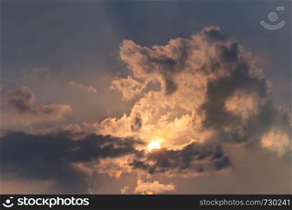Beautiful nature rays of bright sun peep out from behind the clouds on sky. Beautiful nature sun and cloud