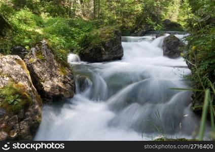 beautiful nature scene with river and waterfall at summer in val di Fassa, italian Dolomites