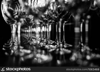 Beautiful new glasses for wine from glass stand in even rows on a wooden table in a restaurant. empty wine glasses. selective focus. empty wine glasses. Beautiful new glasses for wine from glass stand in even rows on a wooden table in a restaurant. selective focus