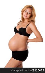 Beautiful new happy mother in late pregnancy wearing black panties and bra, supporting back with hands, isolated.