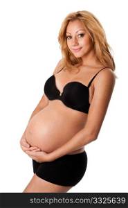 Beautiful new happy mother in late pregnancy wearing black panties and bra, holding belly, isolated.