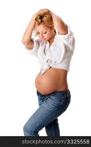 Beautiful new happy mother in late pregnancy wearing fashion jeans and white shirt, looking at tummy, isolated.