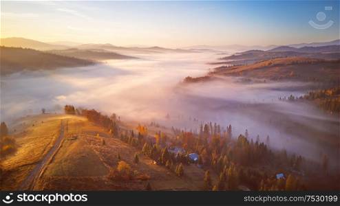 Beautiful November sunrise over mountain foggy valley. Awesome alpine highlands. Wide panorama of beautiful autumn Carpathian mountains, at early morning. Europe, Carpathians, Ukraine