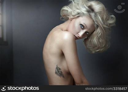 Beautiful nude blonde beauty with tatoo posing