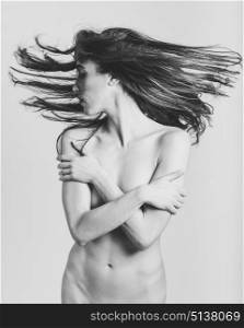 Beautiful nude woman with moving hair on white background.
