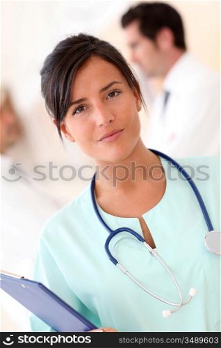 Beautiful nurse standing with medical people