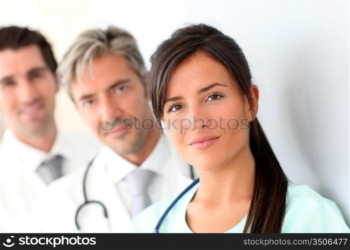 Beautiful nurse standing with medical people