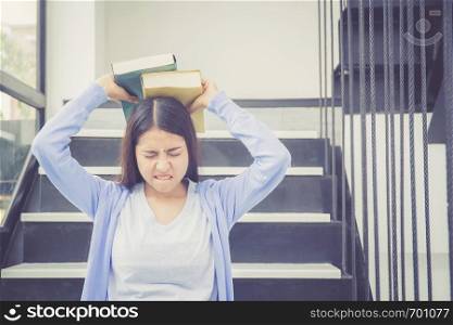 Beautiful of portrait asian young woman holding book, girl tired and bored reading book studying for exams, education and lifestyle concept.