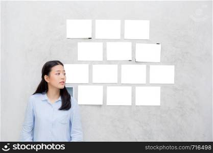 Beautiful of portrait asian young woman standing with picture gallery copy space on wall texture cement background.