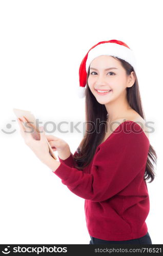 Beautiful of portrait young asian woman in red dress with christmas hat holding tablet isolated on white background, girl with connection digital, communication concept.