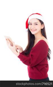 Beautiful of portrait young asian woman in red dress with christmas hat holding tablet isolated on white background, girl with connection digital, communication concept.