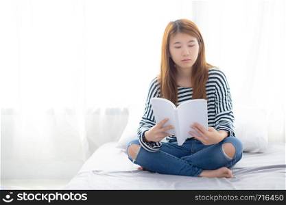 Beautiful of portrait young asian woman relax sitting reading book on bedroom at home, girl study literature, education and llifestyle concept.