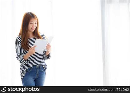 Beautiful of portrait young asian woman relax standing reading book on bedroom at home, girl study literature, education and lifestyle concept.