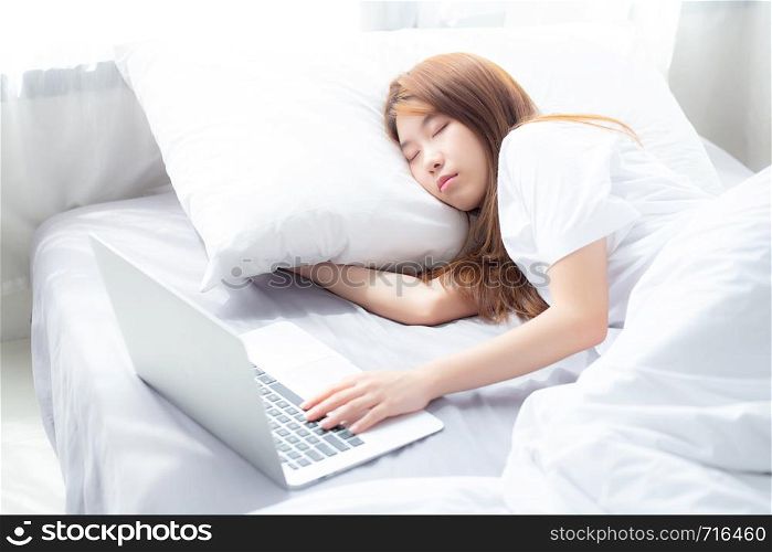 Beautiful of portrait young asian woman with laptop lying down in bedroom, girl tired sleep and relax with computer notebook, resting and healthcare concept.