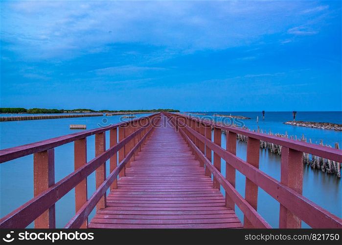 Beautiful of The walkway red wooden bridge in evening at Bang Khun Thian sea view, Bang Khun Thian, Bangkok, Thailand.