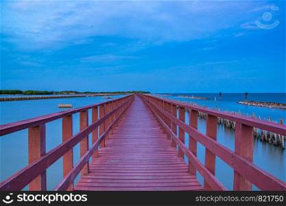 Beautiful of The walkway red wooden bridge in evening at Bang Khun Thian sea view, Bang Khun Thian, Bangkok, Thailand.