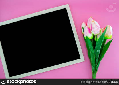 Beautiful of yellow tulip flower and chalkboard, blackboard with flat lay on the pink background, top view, copy space, mother day and holiday concept.