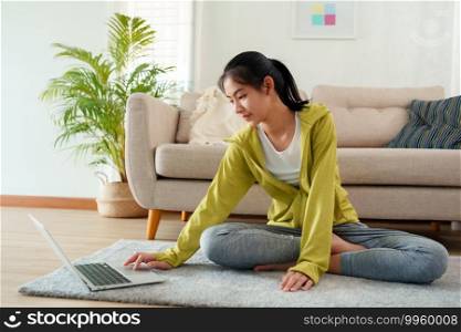 Beautiful of young women Practicing yoga online with Trainer  learning  computer laptop on a yoga mat  at home morning, Concept of relaxation and meditation