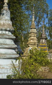 beautiful old colorful chedis on a a thai cemetery