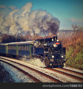 Beautiful old steam train with wagons running on rails at sunset. Excursions for children and parents on festive special days. Czech Republic Europe.