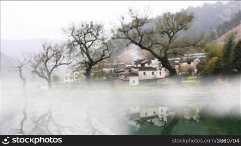 beautiful old village in China, timelapse of fog crossing over water