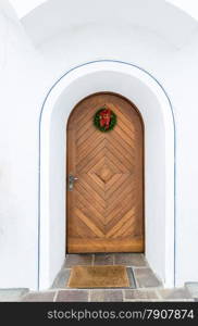 Beautiful old wooden door decorated by Christmas wreath