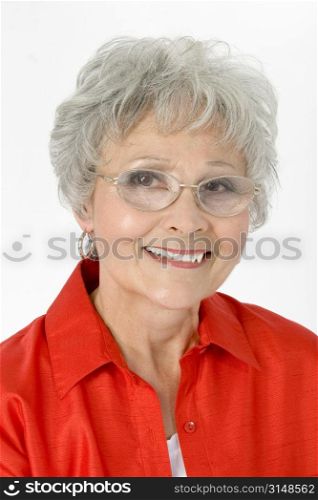 Beautiful older woman in glasses and red shirt over white.