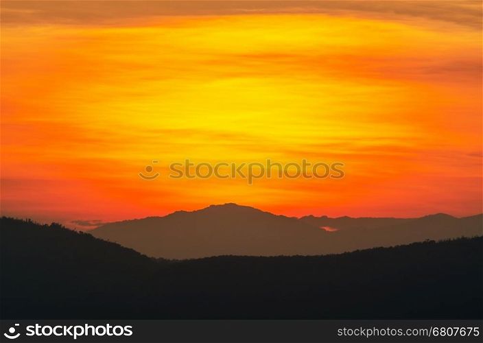 Beautiful orange and red sky over mountain range after sunset
