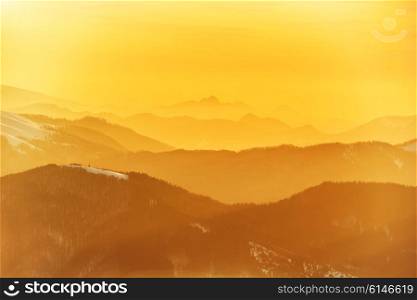 Beautiful orange sunset in mountains with hills and dramatic clouds