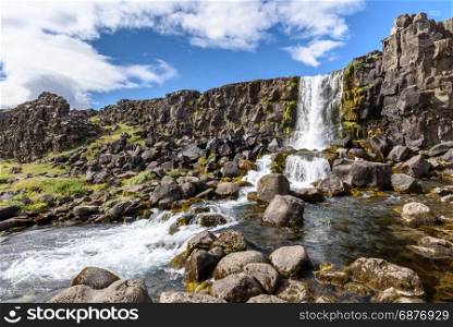 Beautiful Oxararfoss waterfall in summer, Thingvellir National Park, Iceland, selective focus