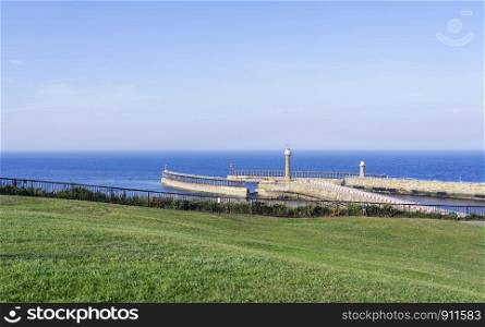 Beautiful panorama landscape lighthouse with green grass and blue sky at Whitby, North Yorkshire, England