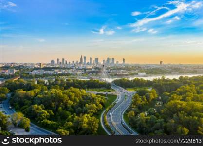 Beautiful panoramic aerial drone view to the Center of modern Warsaw city with silhouettes of skyscrapers in in the rays