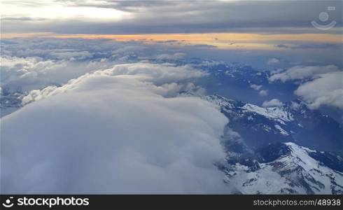 Beautiful panoramic top view on the Alps, covered with snow and clouds