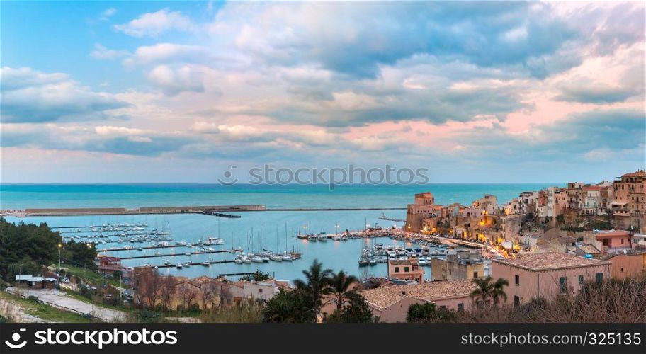 Beautiful panoramic view of medieval fortress in Cala Marina, harbor in coastal city Castellammare del Golfo at sunset, Sicily, Italy. Castellammare del Golfo at sunset, Sicily, Italy
