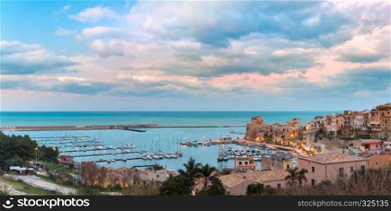 Beautiful panoramic view of medieval fortress in Cala Marina, harbor in coastal city Castellammare del Golfo at sunset, Sicily, Italy. Castellammare del Golfo at sunset, Sicily, Italy