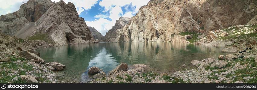 Beautiful panoramic view of mountains and lake with reflection. Scenary nature landscape. Lake Kelsuu, Kyrgyzstan.