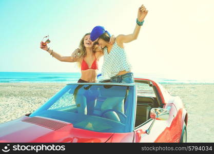 Beautiful party friend girls dancing in a car on the beach happy