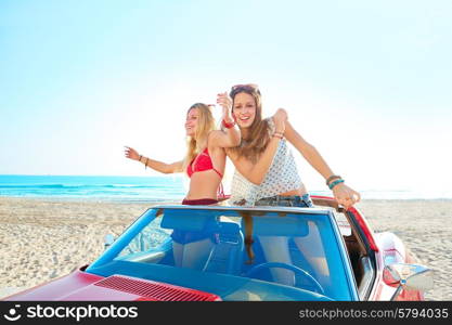 Beautiful party friend girls dancing in a car on the beach happy