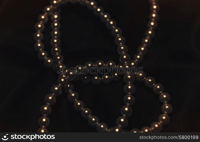 beautiful pearl necklace on a black silk close up