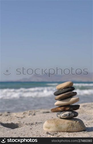beautiful pebble stack on a sandy beach (sea on the background)