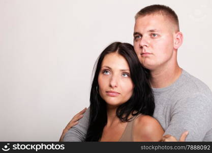 Beautiful pensive man and woman stand near gray wal